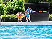 Moderne Gartenbox aus hochwertigem Stahl in anthrazit steht gefüllt mit Spielsachen am Rand eines Pools. Zwei Kinder springen gerade ins Wasser