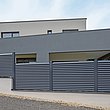 Lamellenzaun in grau mit Sichtschutz vor Haus mit moderner Architektur
