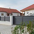Zaun mit Lamellen als Sichtschutz in grau und Gartentor,sowie Gartentür umzäunt eine moderne Hausanlage 