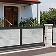 elektrisches Schiebetor und Gartentür mit Lochblech als Sichtschutz zur Hauseinfahrt
